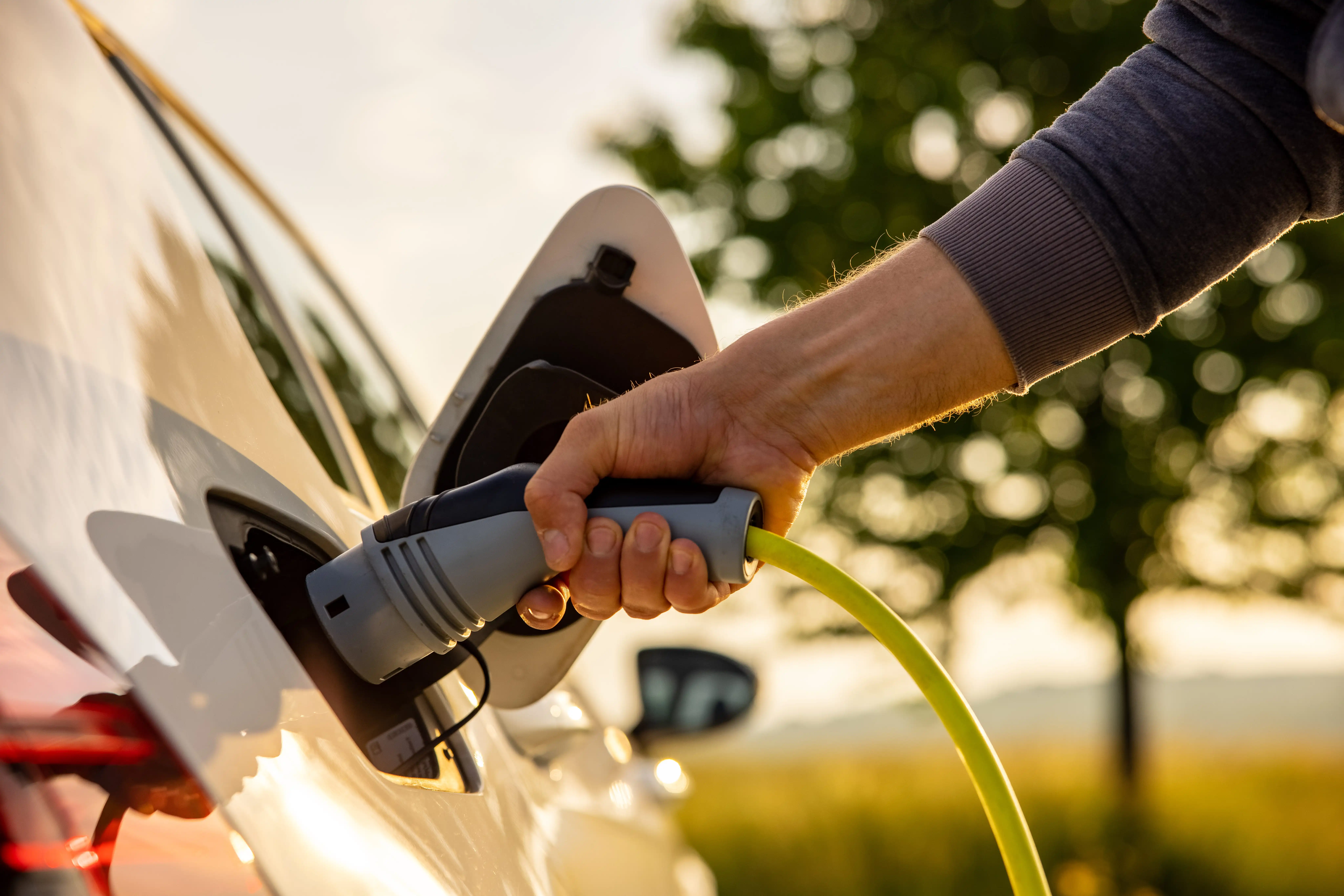 Close up of hands charging electric vehicle